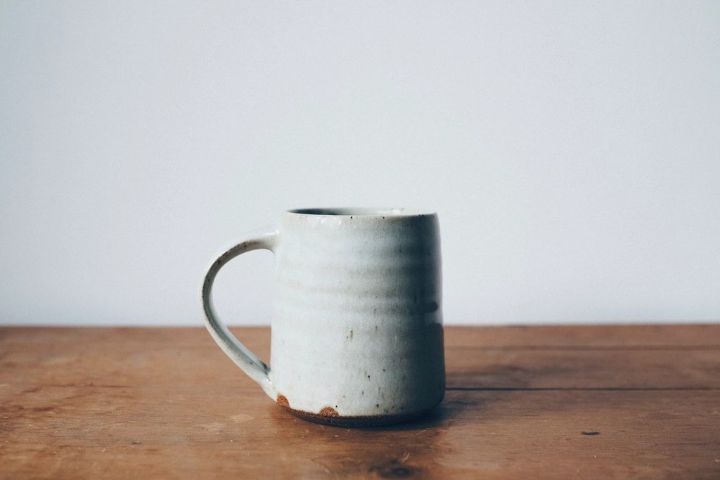 A speckled stoneware mug on a wooden table
