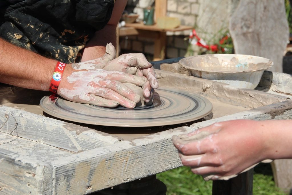Hands centering clay on a potter's wheel